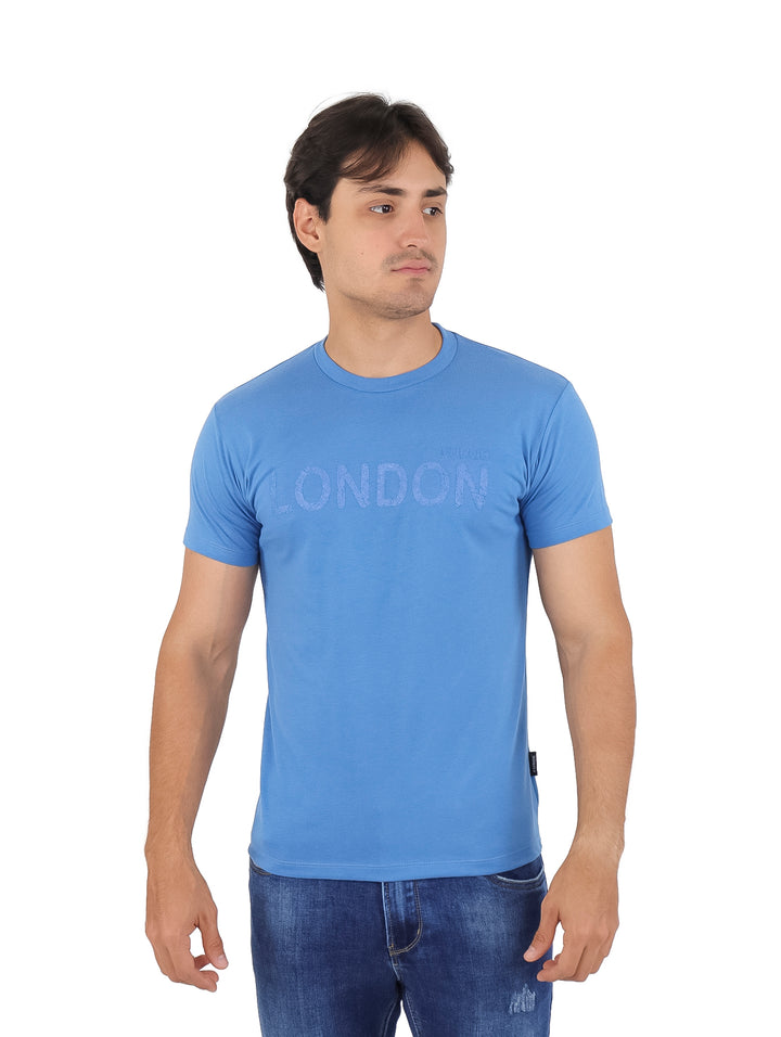 Hombre vistiendo una playera azul de manga corta con el texto &