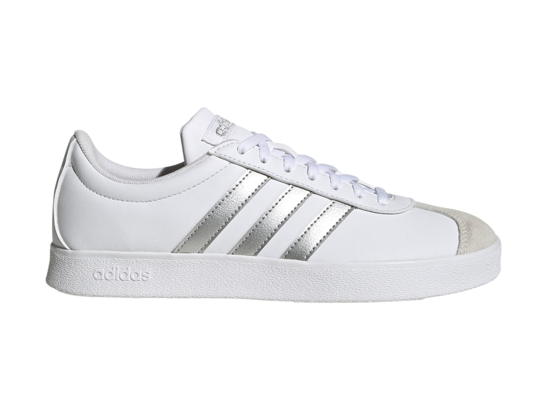 Tenis Adidas blancos con tres franjas plateadas y punta gris, vista lateral.