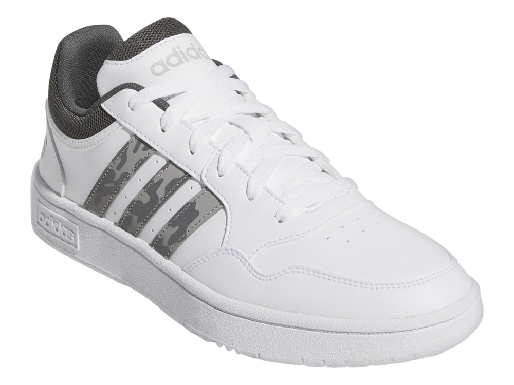 Tenis Adidas blancos con detalles en gris y rayas laterales con patrón de camuflaje.