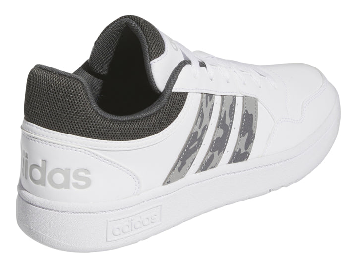 Tenis Adidas blancos con detalles en gris y rayas laterales con patrón de camuflaje.