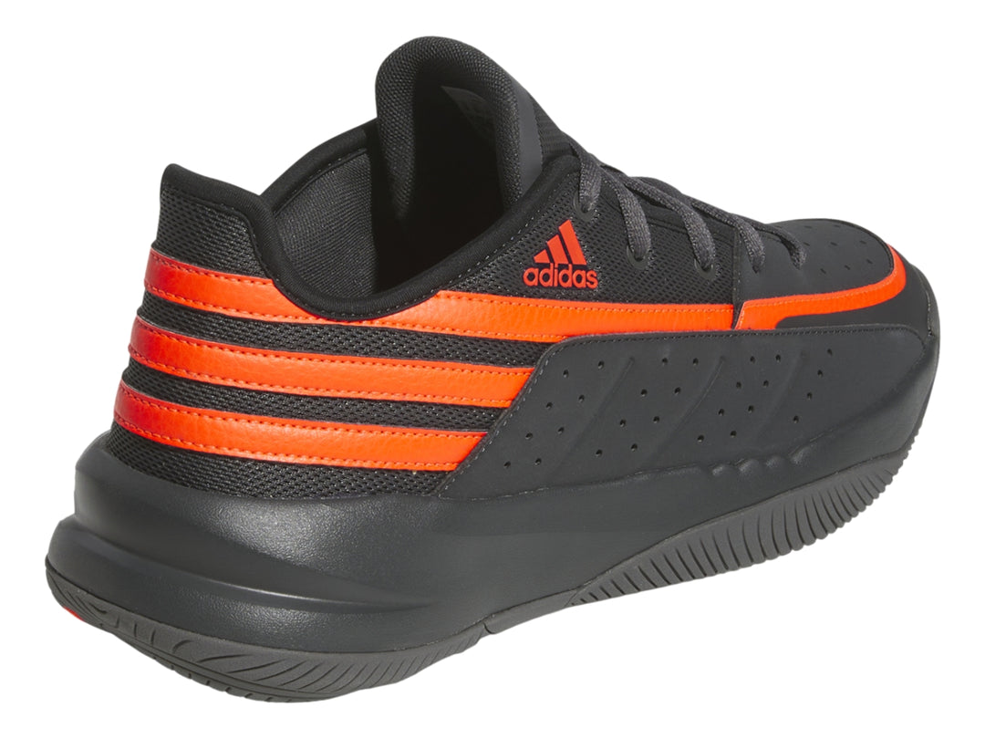 Tenis deportivos Adidas color gris oscuro con tres franjas laterales y detalles en naranja brillante.