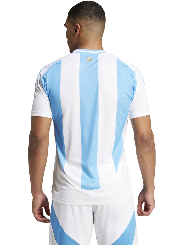 Hombre vistiendo la camiseta local de la Selección Argentina en color blanco y azul claro.