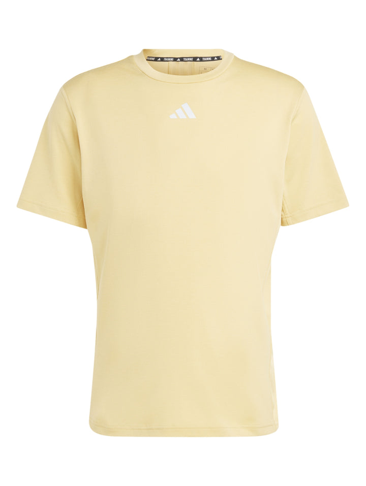 Hombre vistiendo una camiseta deportiva Adidas de color beige claro y shorts blancos.