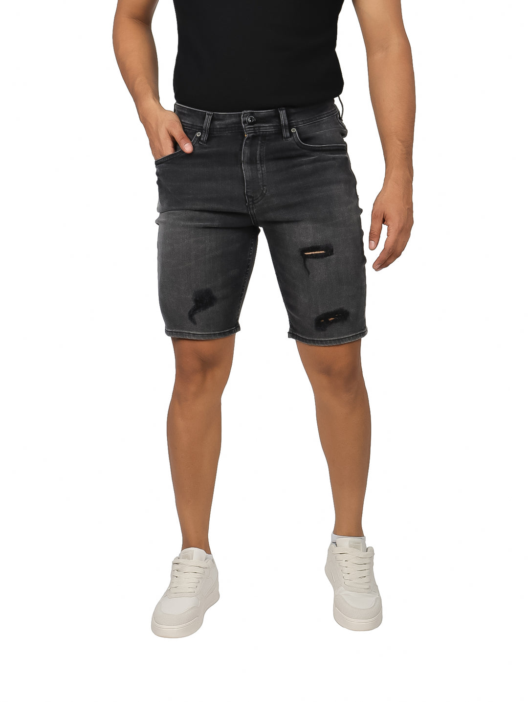 Hombre vistiendo bermudas de mezclilla color negro con detalles desgastados y rotos en las piernas.