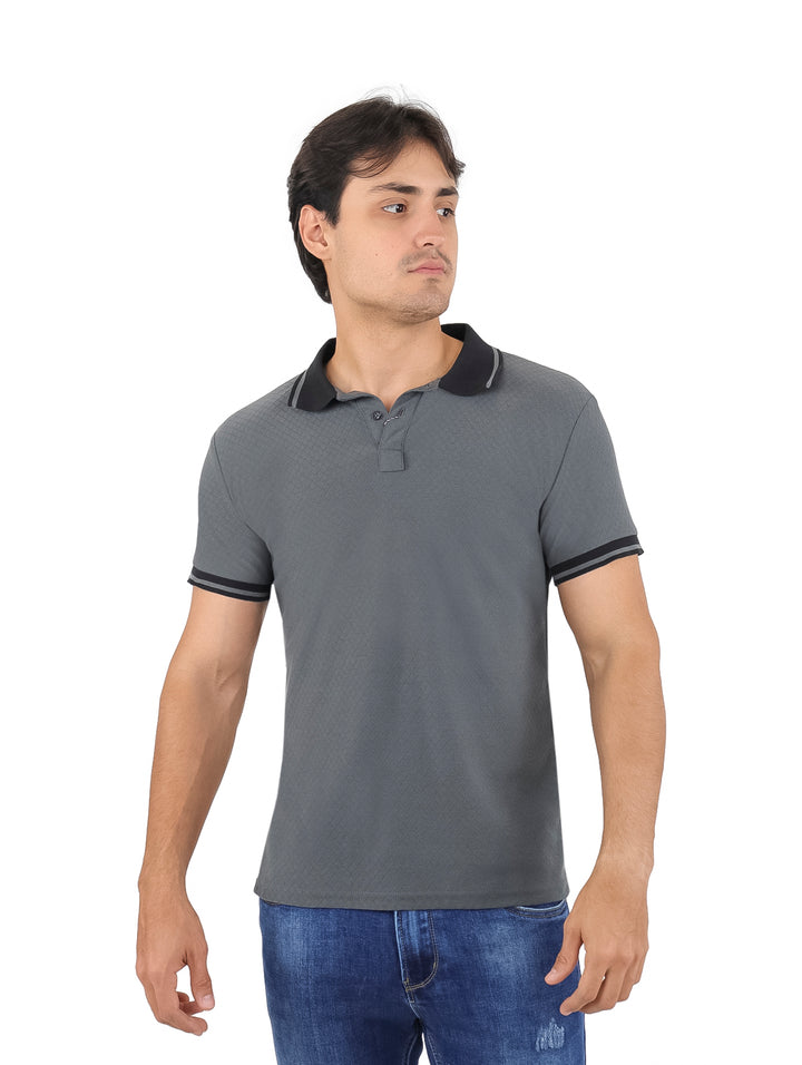 Hombre vistiendo playera polo color gris oxford con detalles en negro en cuello y mangas.
