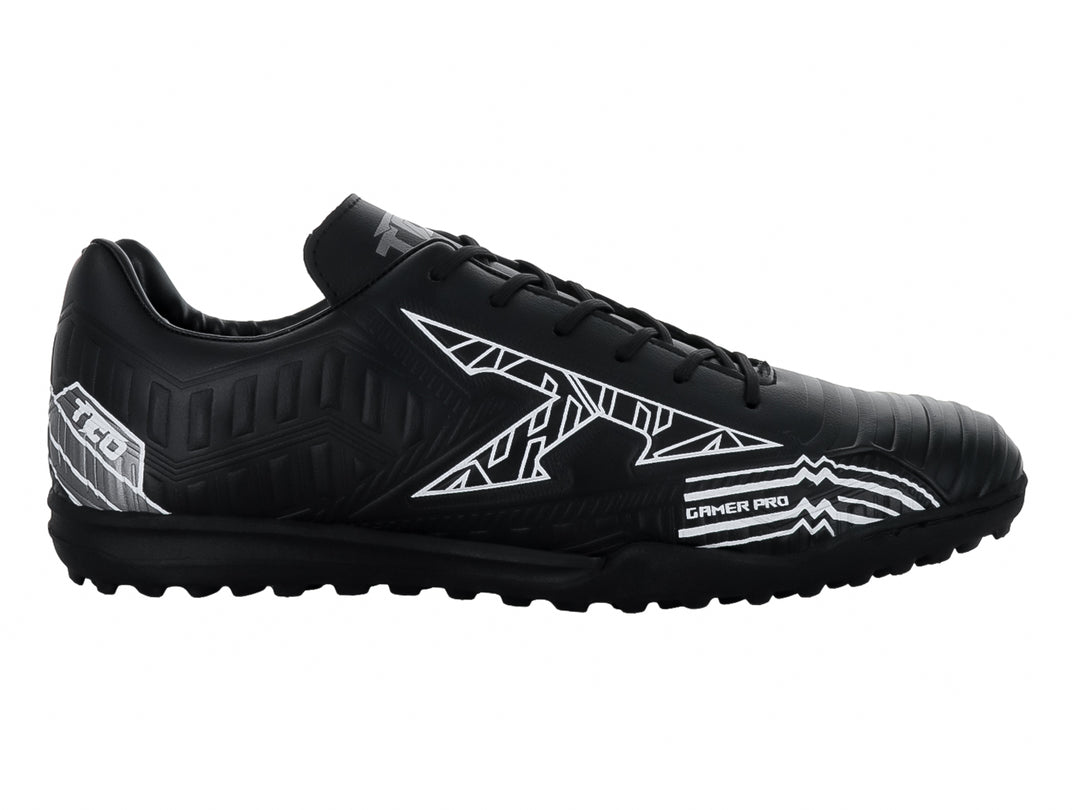 Zapato de fútbol Leon Trucco FT90 color negro con detalles gráficos en blanco y suela para pasto sintético.