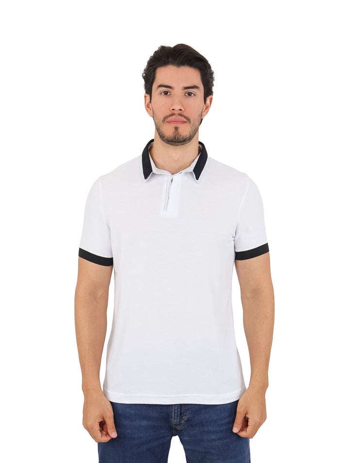Hombre vistiendo playera polo blanca con detalles en negro en el cuello y mangas.