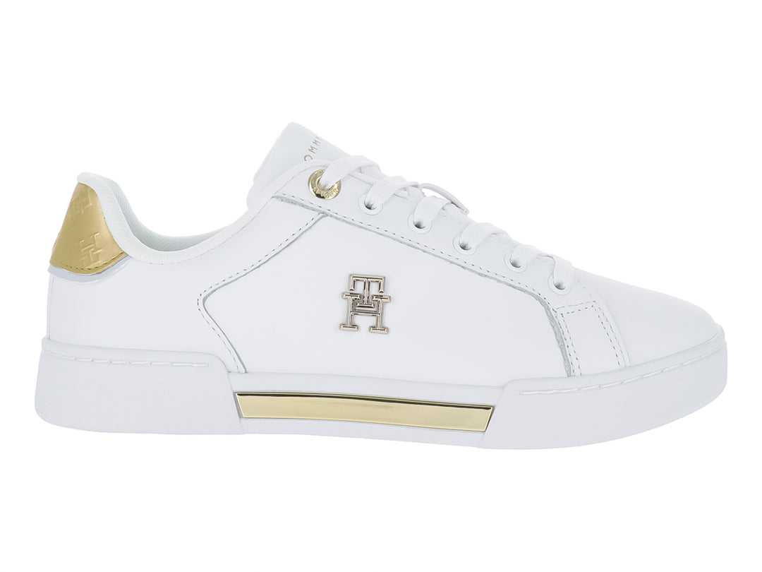 Tenis blancos Tommy Hilfiger con detalles dorados en el talón y la suela.