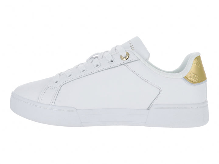 Tenis blancos Tommy Hilfiger con detalles dorados en el talón y la suela.