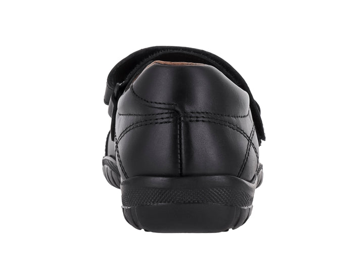 Zapato escolar negro con correa de ajuste y suela negra.