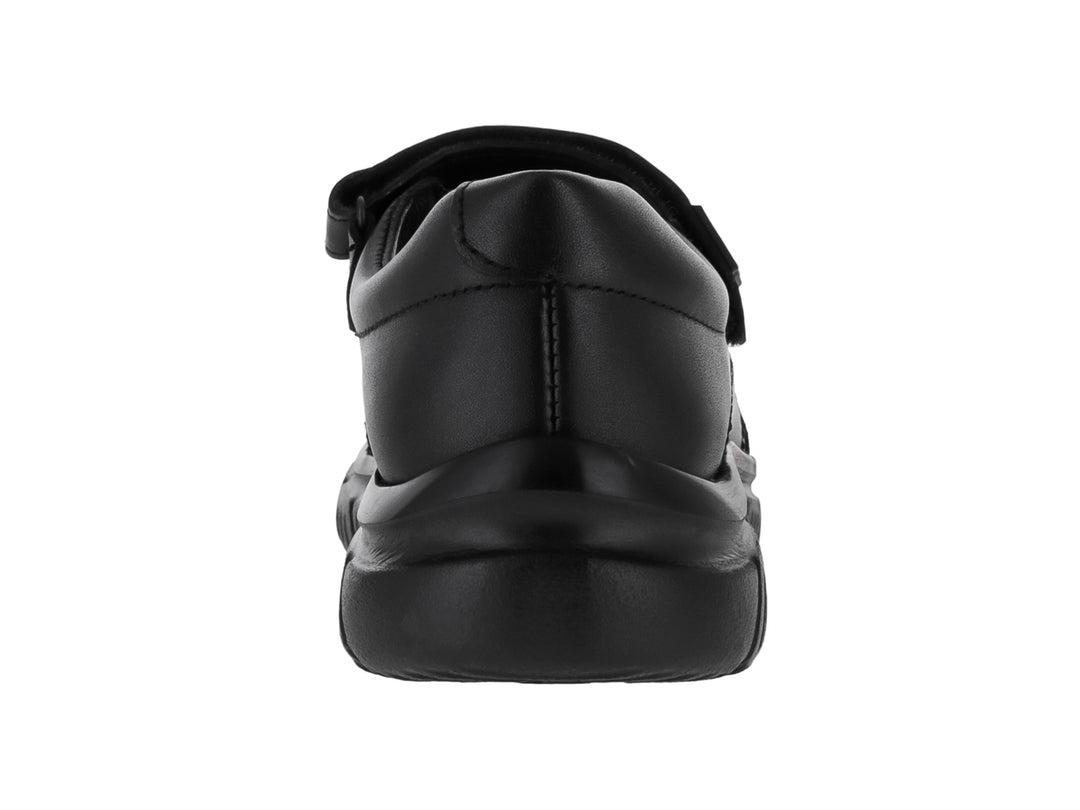 Zapato negro para niño o niña con cierre de correa velcro y suela robusta sobre fondo blanco.