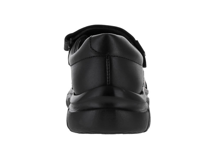Zapato negro para niño o niña con cierre de correa velcro y suela robusta sobre fondo blanco.