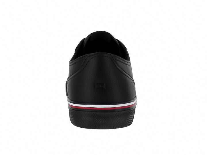 Tenis negros de cuero Tommy Hilfiger con detalle de franja roja y blanca en la suela.