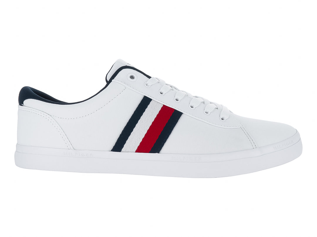 Tenis blancos Tommy Hilfiger con franjas laterales en azul marino y rojo y suela blanca.