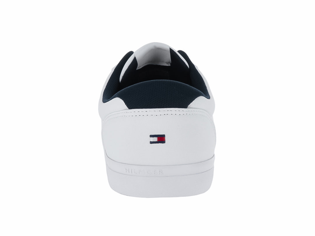 Tenis blancos Tommy Hilfiger con franjas laterales en azul marino y rojo y suela blanca.
