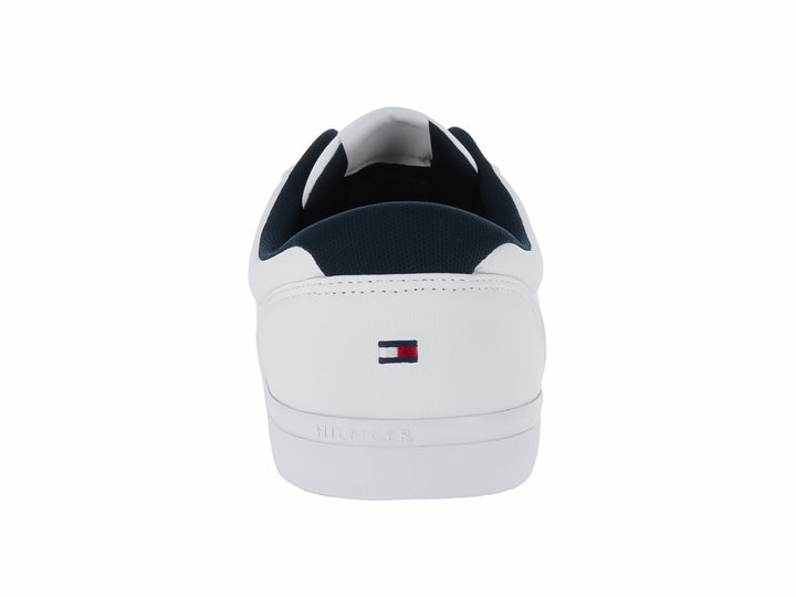 Tenis blancos Tommy Hilfiger con franjas laterales en azul marino y rojo y suela blanca.