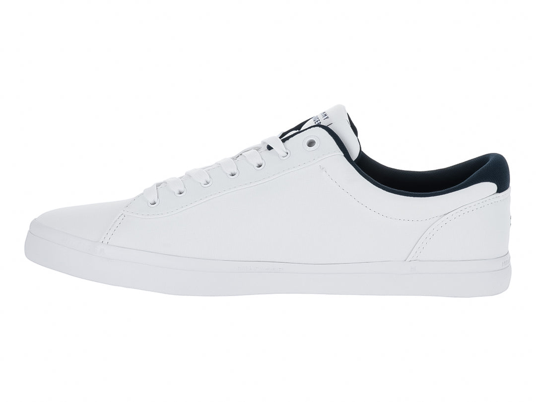 Tenis blancos Tommy Hilfiger con franjas laterales en azul marino y rojo y suela blanca.