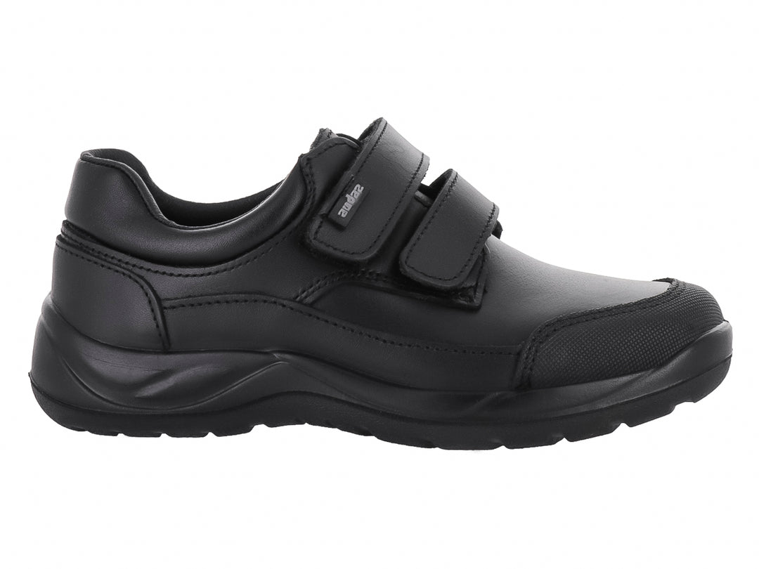 Zapato infantil color negro con cierre de dos correas de velcro y suela gruesa.