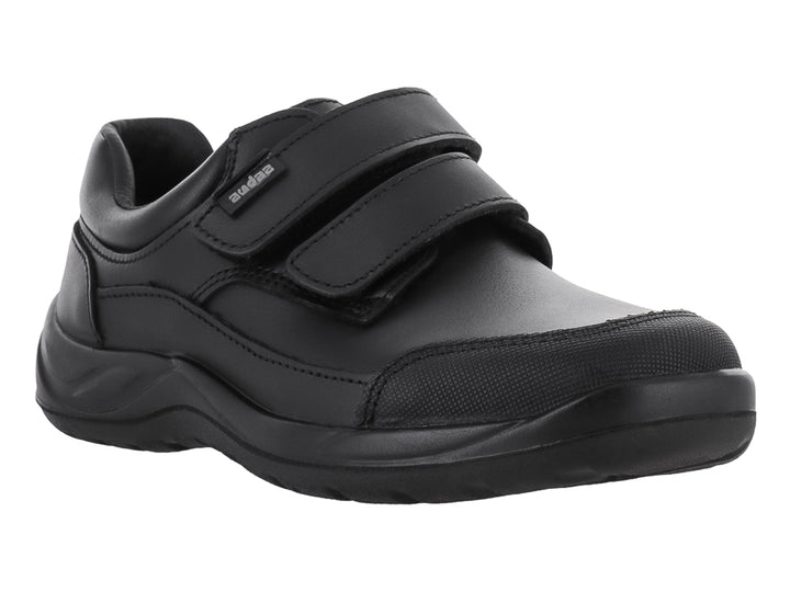 Zapato infantil color negro con cierre de dos correas de velcro y suela gruesa.