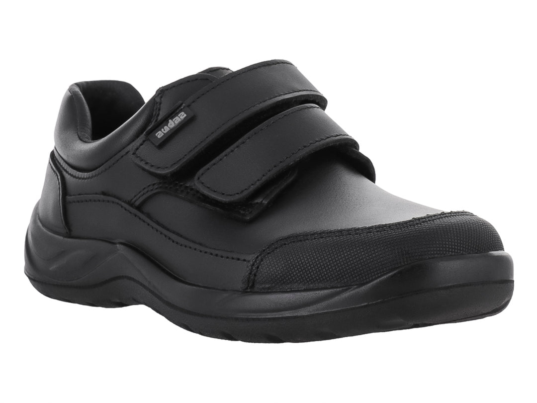 Zapato infantil color negro con cierre de velcro y suela gruesa.