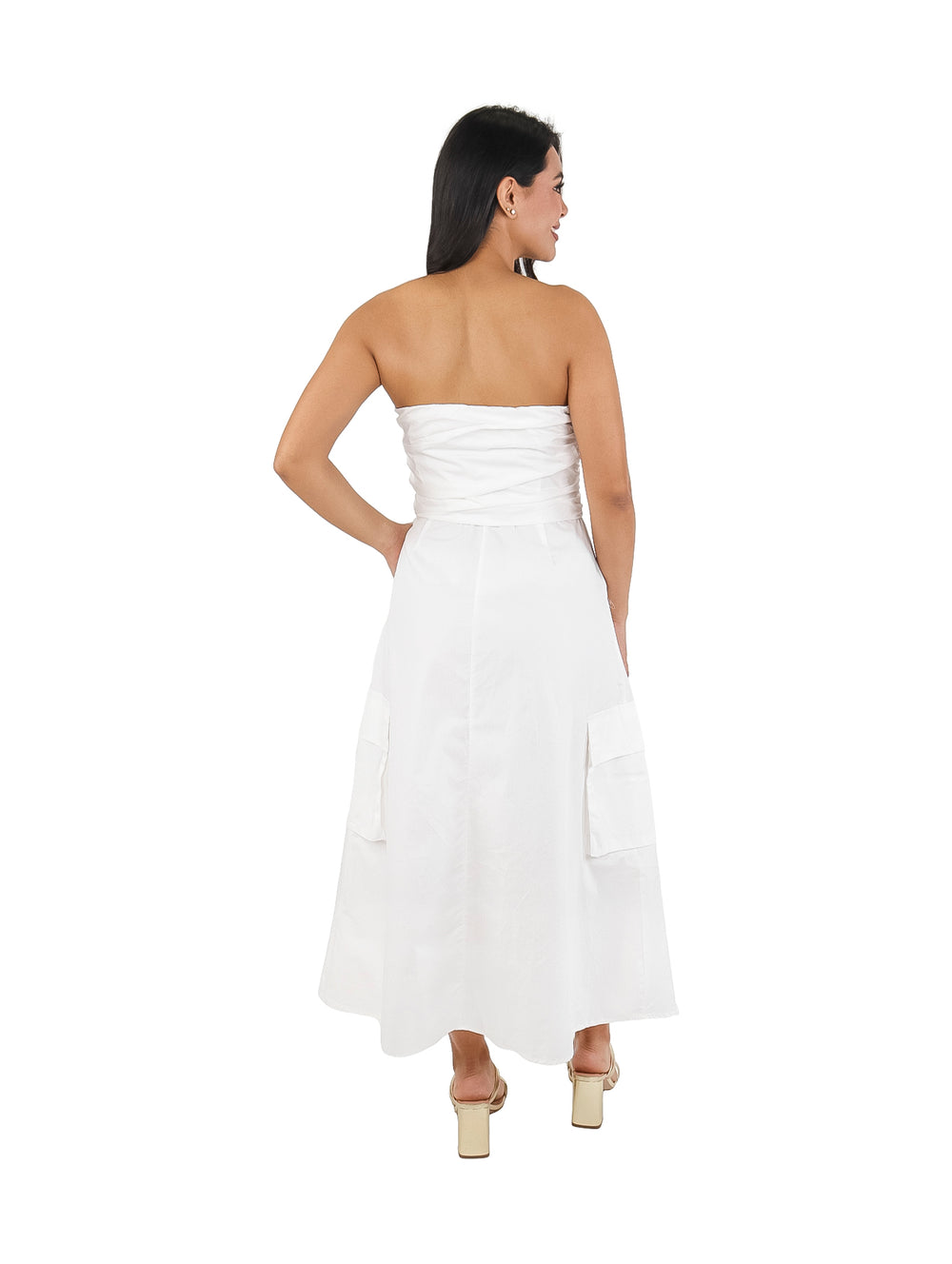 Mujer vistiendo un vestido strapless blanco de corte ancho con bolsillos laterales.