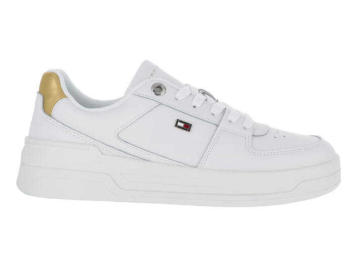 Tenis Tommy Hilfiger color blanco con detalle dorado en el talón y suela ancha blanca.