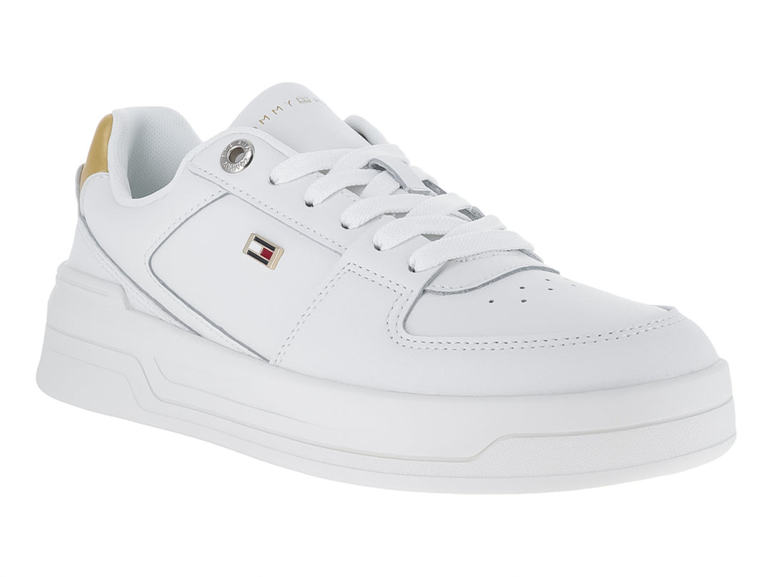 Tenis Tommy Hilfiger color blanco con detalle dorado en el talón y suela ancha blanca.