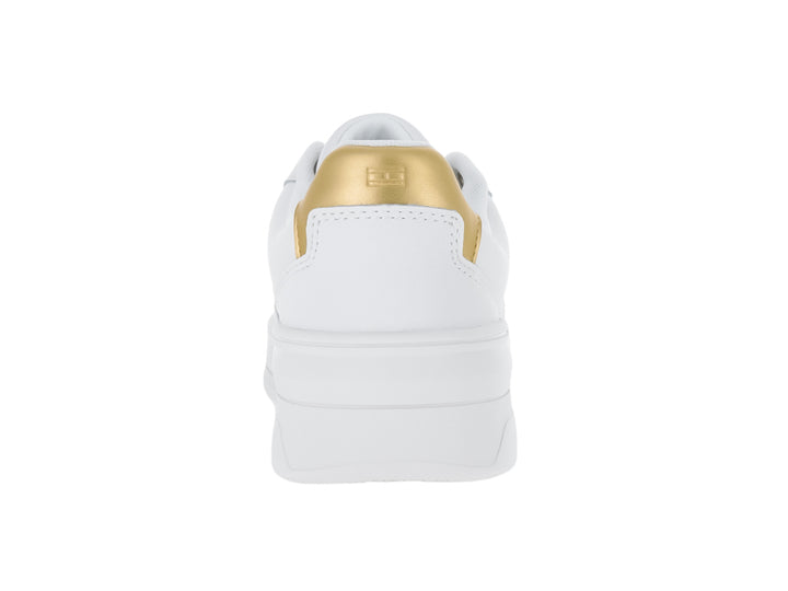 Tenis Tommy Hilfiger color blanco con detalle dorado en el talón y suela ancha blanca.