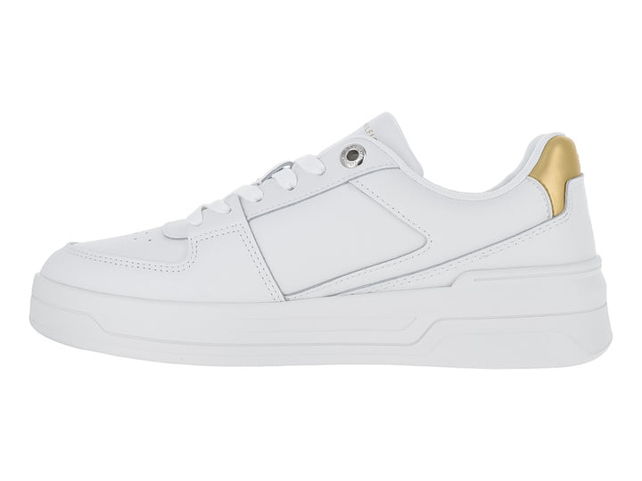 Tenis Tommy Hilfiger color blanco con detalle dorado en el talón y suela ancha blanca.