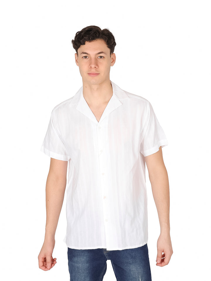 Hombre vistiendo una camisa blanca de manga corta marca Losan y pantalones azules.