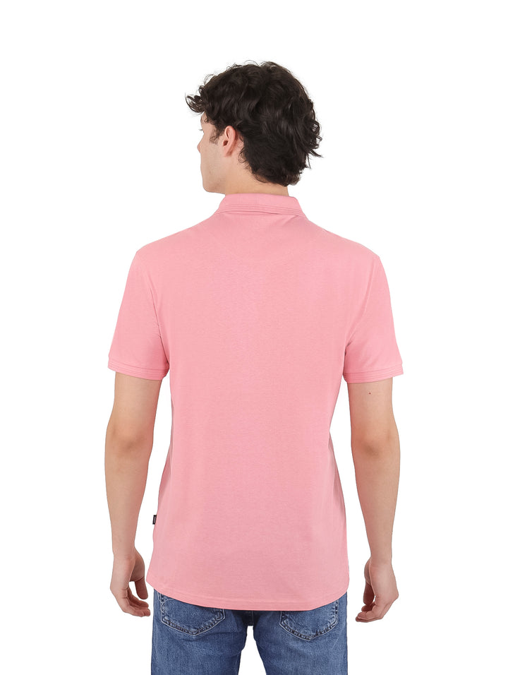 Hombre vistiendo una playera polo de color rosa con manga corta y cuello.