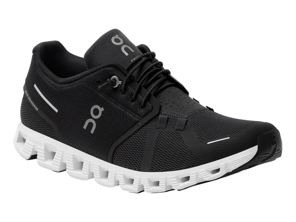 Tenis deportivos On Cloud 5 en color negro con suela blanca segmentada y detalles minimalistas.