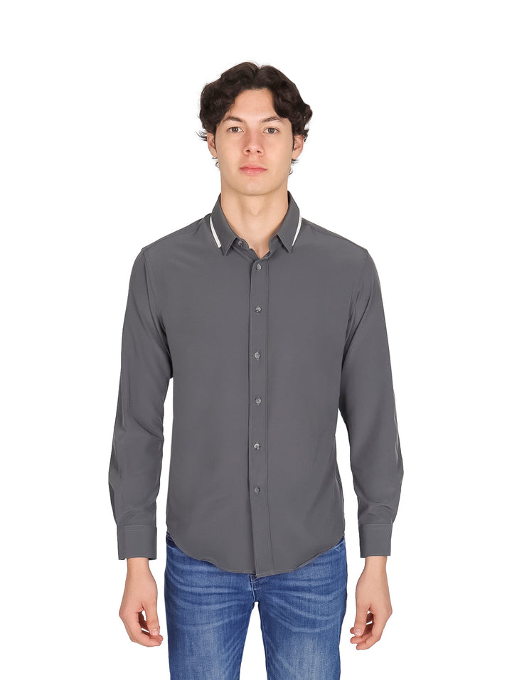 Hombre vistiendo una camisa gris de manga larga con botones y cuello.