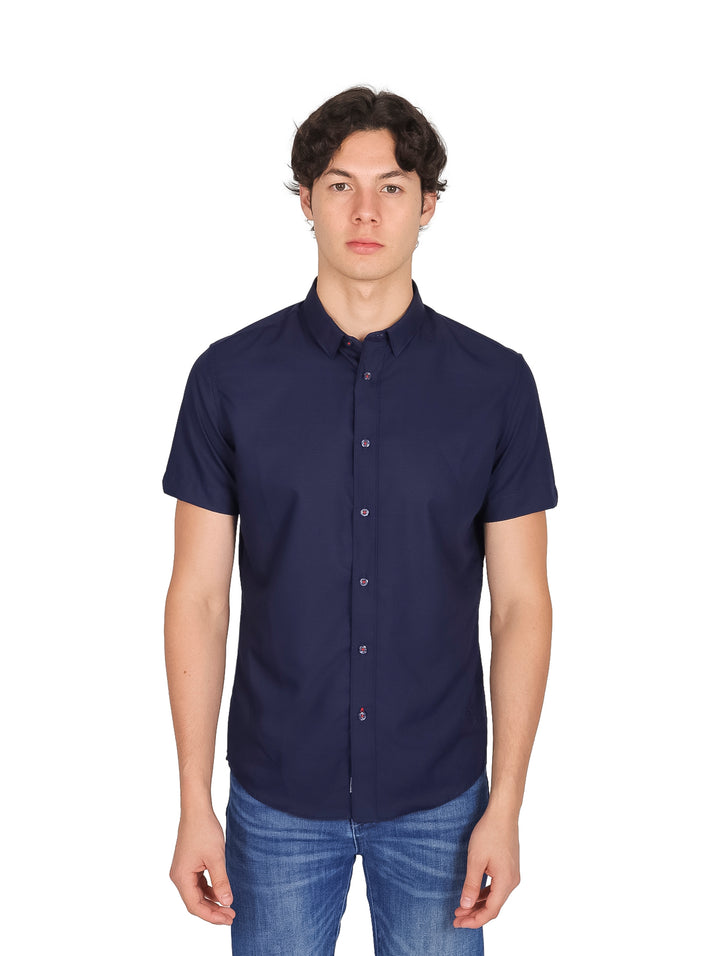 Hombre vistiendo una camisa de manga corta color azul marino con cuello y botones.
