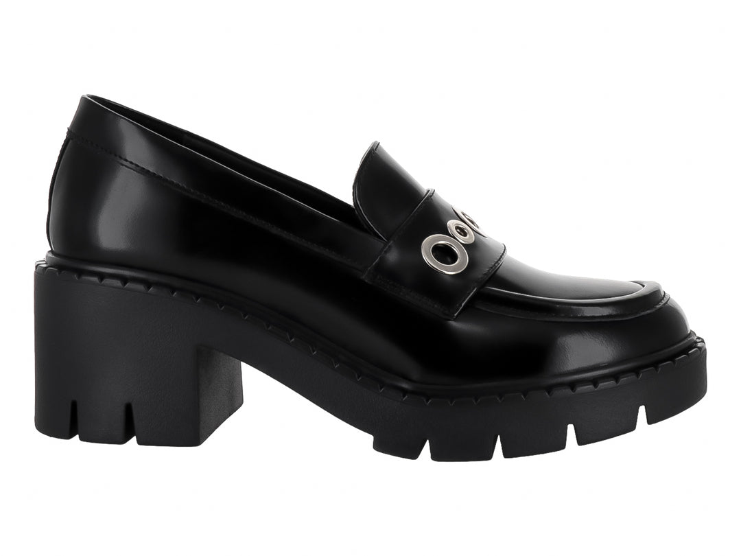 Zapato tipo mocasín negro brillante con plataforma gruesa y detalle de argollas plateadas en el empeine.