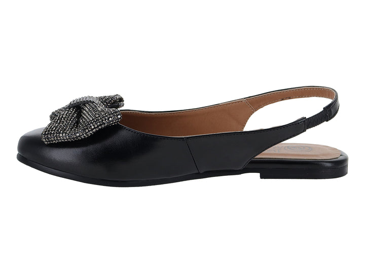 Zapato plano tipo mule color negro con un moño decorativo de pedrería brillante en la parte frontal.