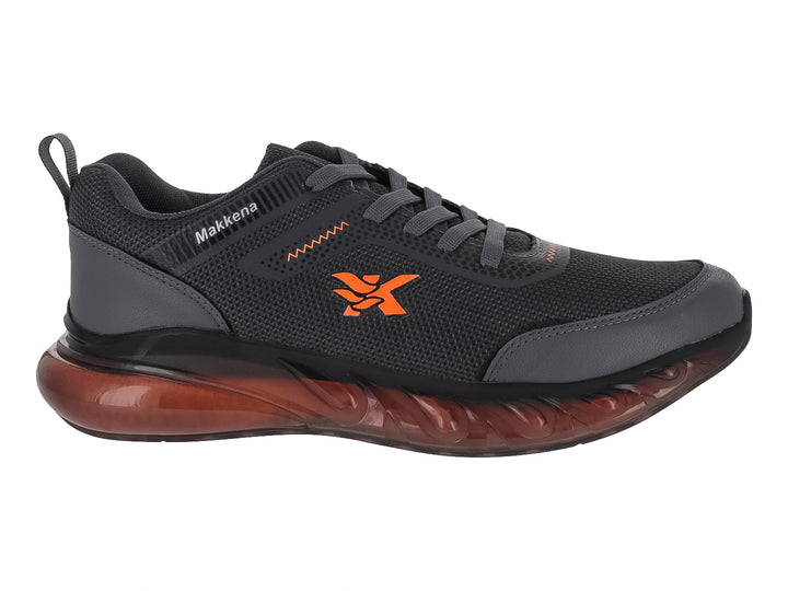 Zapato deportivo para niño marca Makkena en color gris oscuro con detalles y suela en tono naranja.