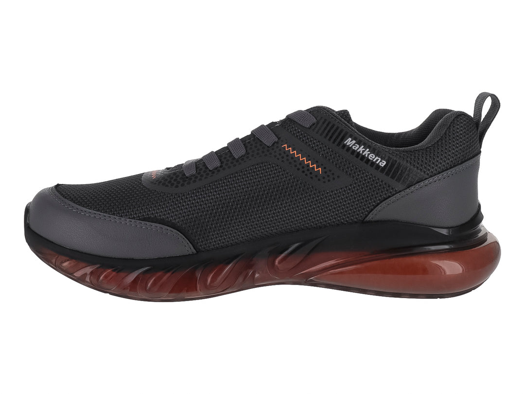 Zapato deportivo para niño marca Makkena en color gris oscuro con detalles y suela en tono naranja.