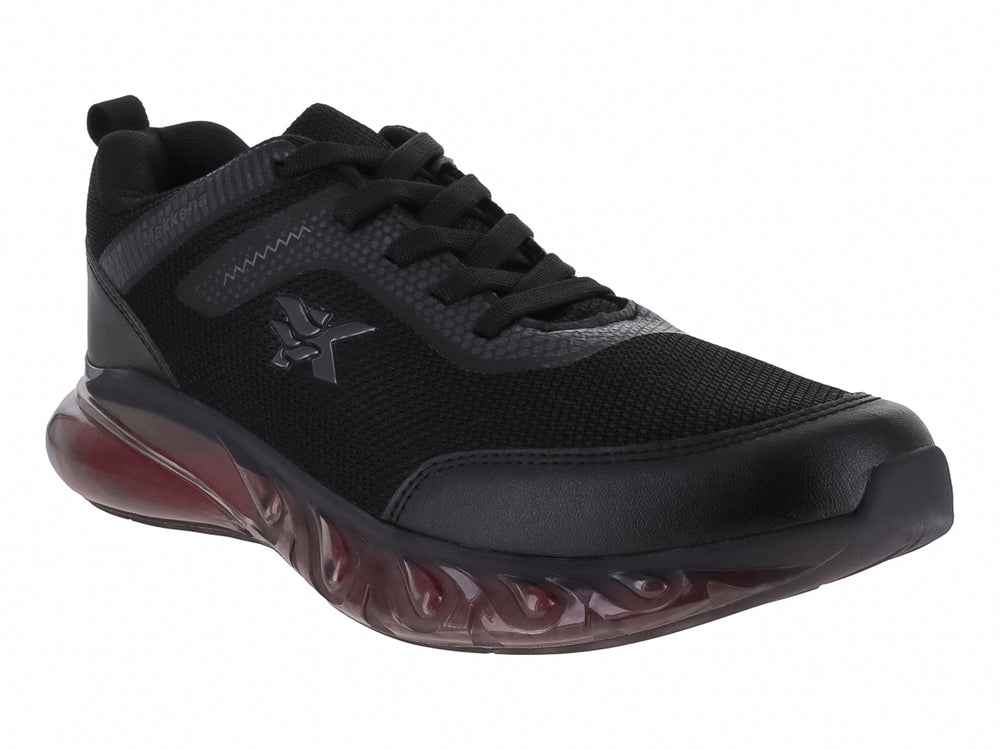 Tenis deportivo infantil color negro con suela translúcida rojiza.