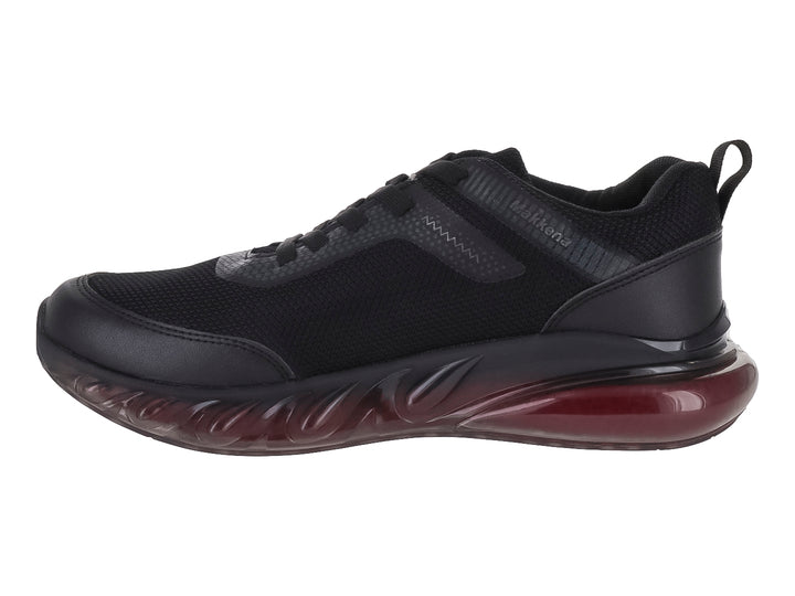 Tenis deportivo infantil color negro con suela translúcida rojiza.