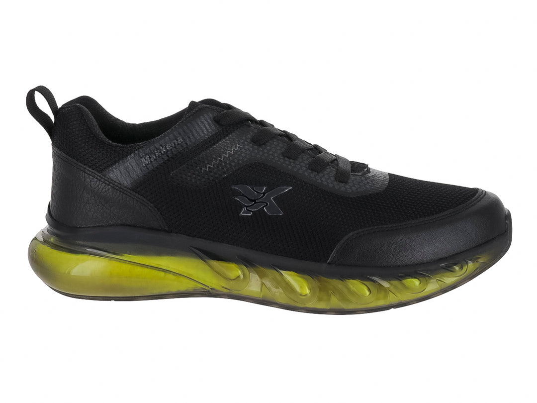 Tenis deportivos infantiles color negro con suela gruesa translúcida en amarillo neón.