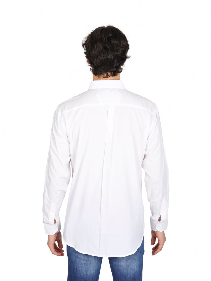 Hombre vistiendo una camisa blanca de manga larga con cuello y un bolsillo frontal.