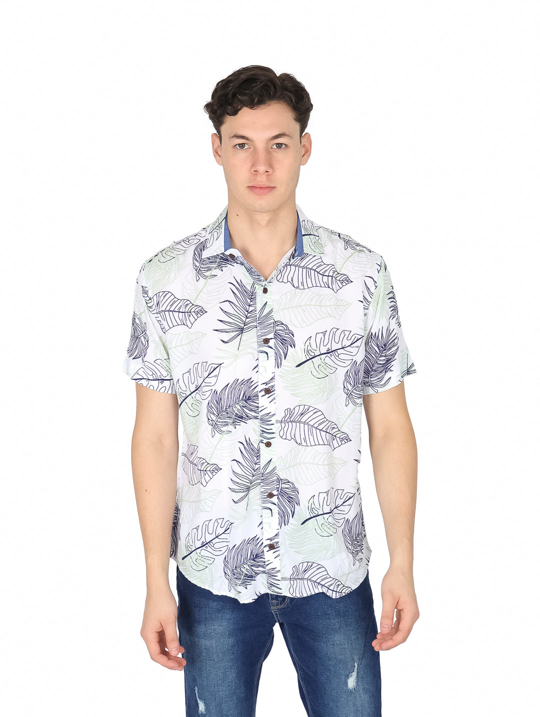 Hombre vistiendo camisa blanca de manga corta con estampado de hojas tropicales verdes y azules.