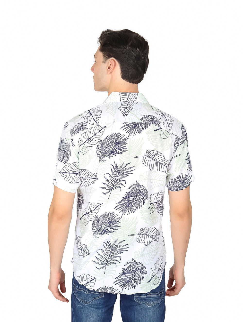 Hombre vistiendo camisa blanca de manga corta con estampado de hojas tropicales verdes y azules.