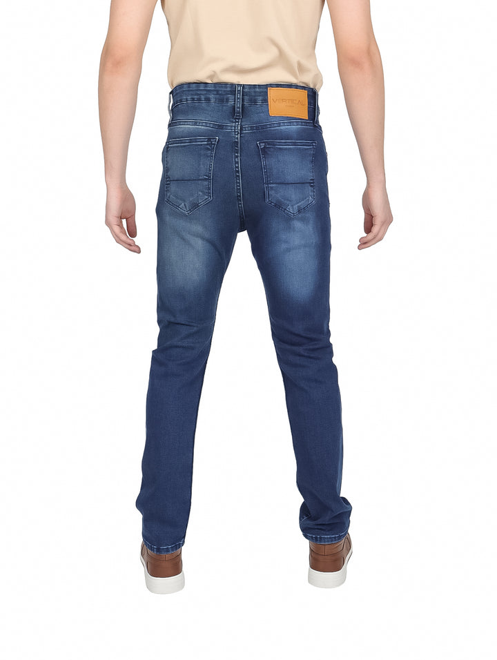 Hombre vistiendo pantalones jeans slim fit color azul marino con calzado café.