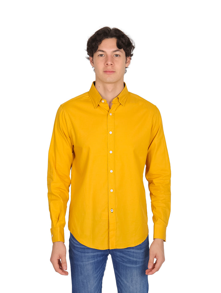 Hombre vistiendo una camisa lisa de color mostaza con manga larga y cuello.