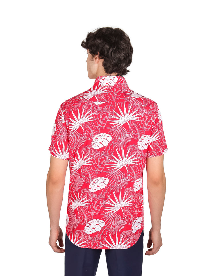 Hombre vistiendo camisa roja de manga corta con estampado de hojas blancas y pantalones azul marino.