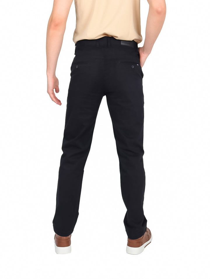 Hombre vistiendo pantalón de gabardina color negro en corte slim fit.