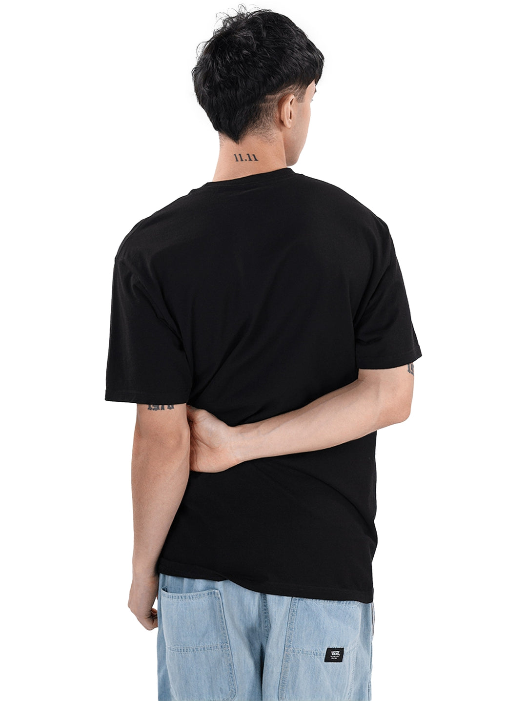 Hombre vistiendo camiseta negra VANS de manga corta con gráfico blanco de una flor y texto.