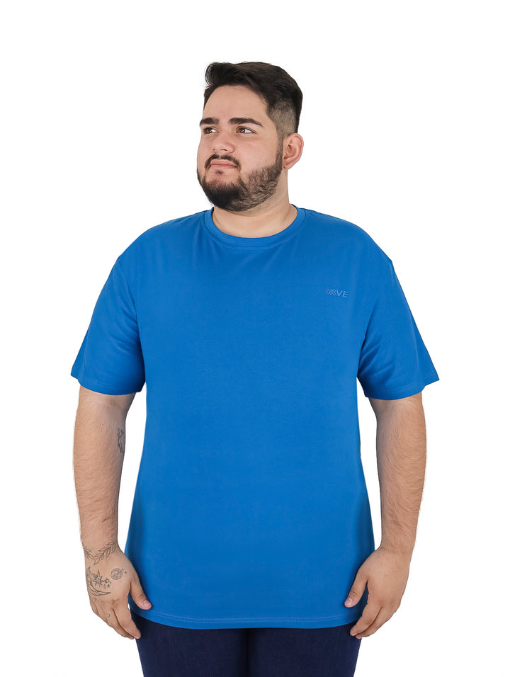 Hombre vistiendo una playera de manga corta color azul aqua de corte amplio.